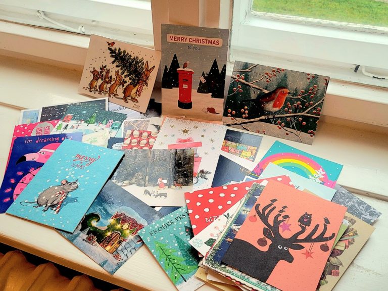 Weihnachtspost 2022 - sehr viele bunte Postkarten auf dem Fensterbrett
